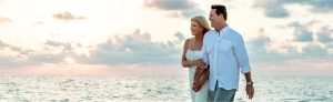 Breast cancer survivor Catherine Haffey walking on the beach with her husband